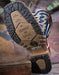 Close-up of a boot sole with 'Trust in L.C.E.' and 'Double H' branding on a rustic background.