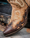 closeup of snip toe western toe with brown leather overlay and brass rivet details