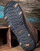 Brown boot with a detailed tread pattern on a wooden surface
