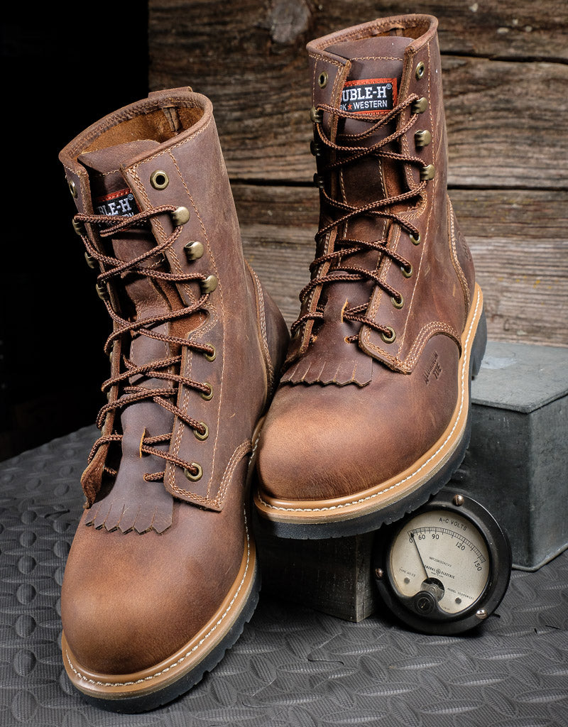 brown pair of boots sitting propped up on a grey box 