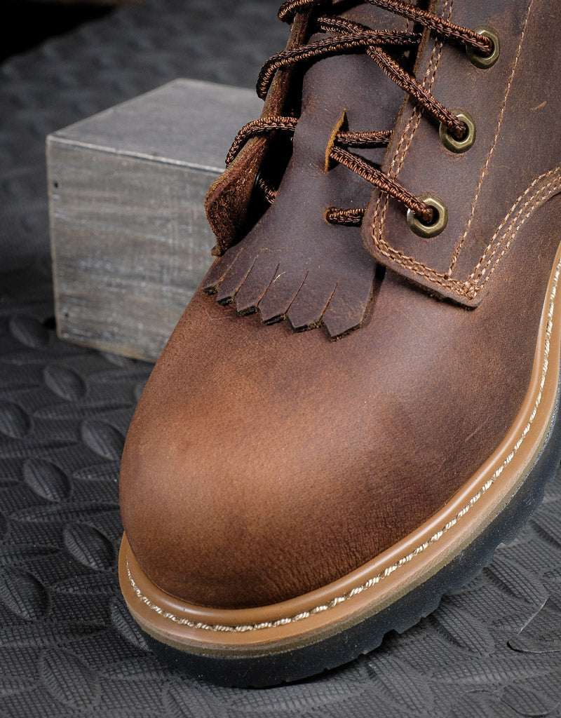 Close up on round toe laceup boot toe, the boot has a kiltie laced into the laces