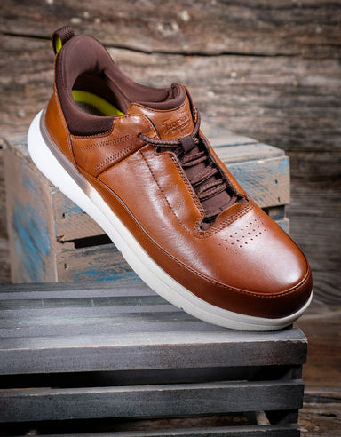 Brown leather shoe on a wooden pallet with a rustic background