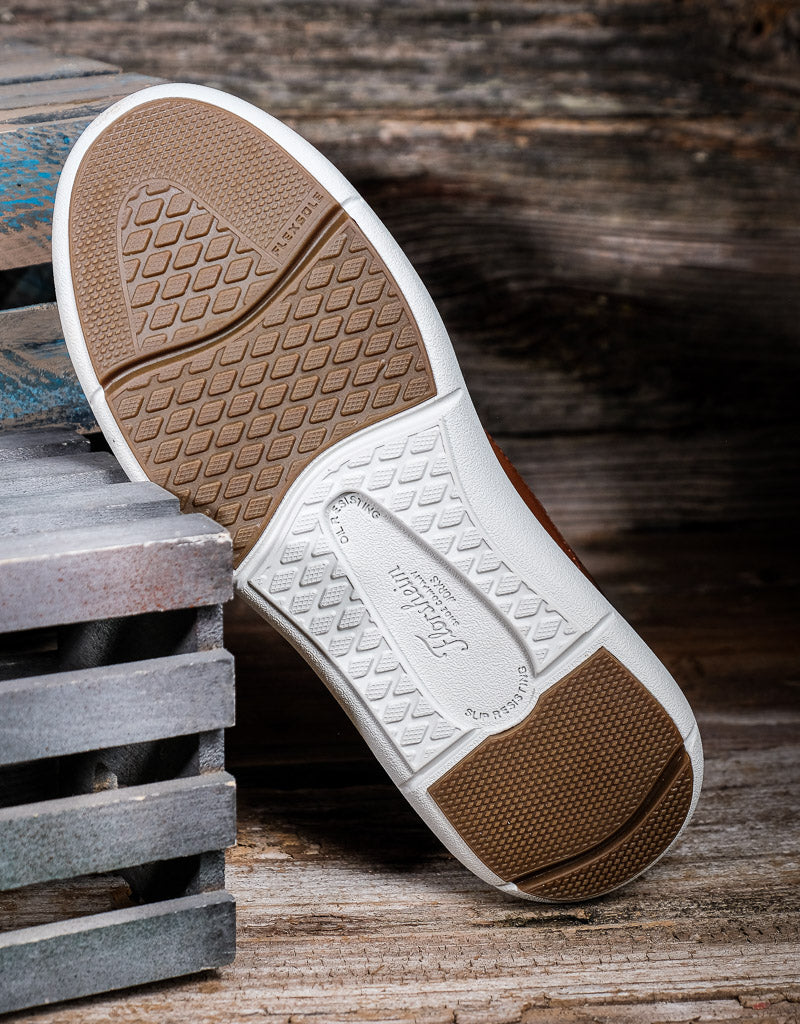 Close-up of a shoe sole with brand logo on a wooden surface