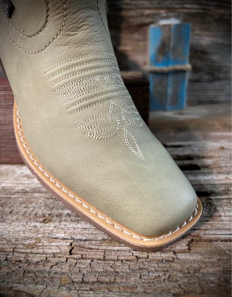 Light bone cowboy boot with tan sole on a wooden surface