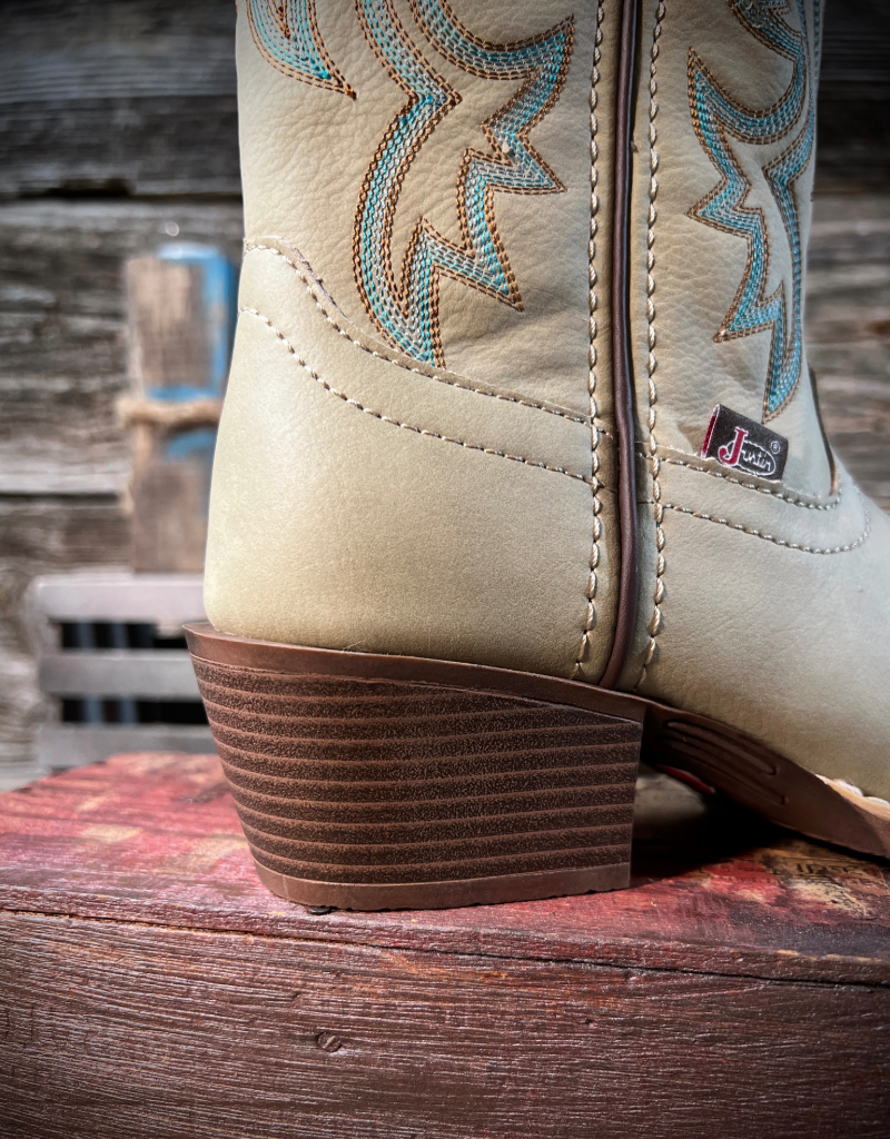 Close-up of an off white cowboy boot with turquoise stitching on a wooden surface.
