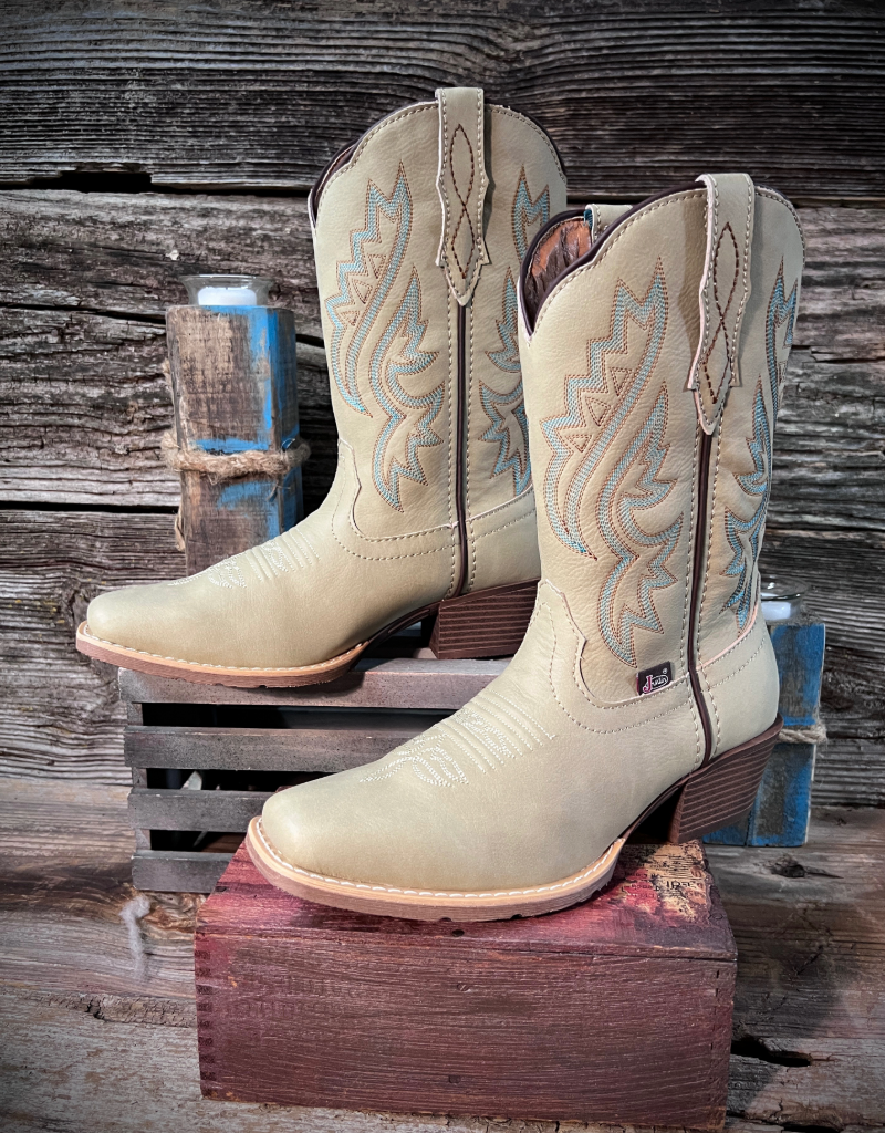 Pair of bone colored cowboy boots with intricate designs on a wooden stand against a rustic wooden background.