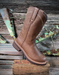 Brown leather boot on a wooden block with rustic background