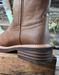 Brown leather boot with a thick sole on a wooden surface
