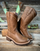 Pair of brown leather boots on a wooden surface