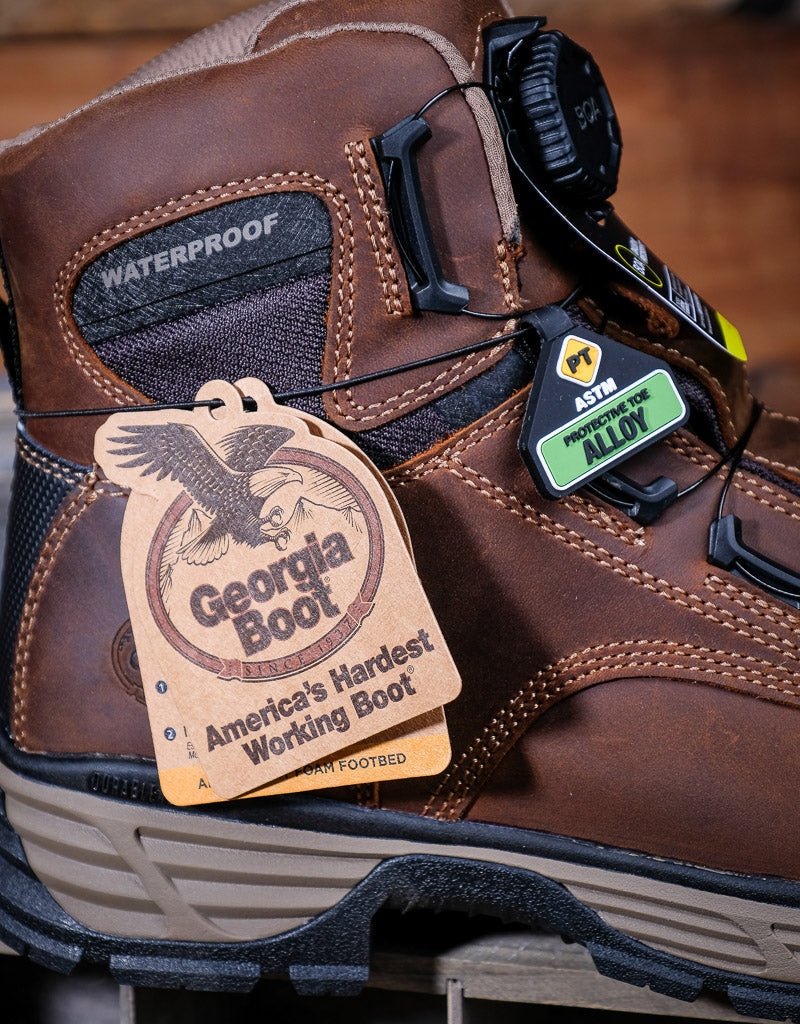 Brown work boot with Georgia Boot tag and label on a wooden surface