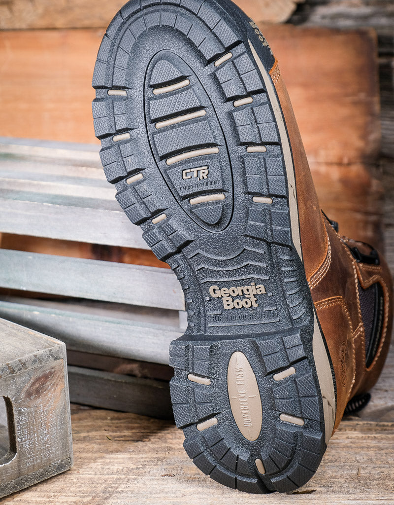 Close-up of a black boot sole with a Georgia Boot label on a wooden surface.
