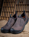 Pair of brown slip-on shoes with black soles on a rustic wooden background