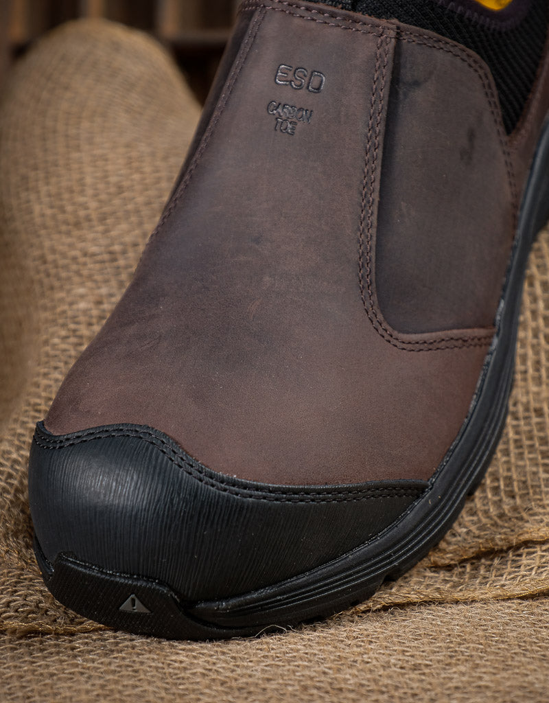 Brown slip-on shoe with black sole on a burlap background