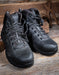 Pair of black tactical boots on a wooden surface