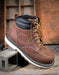 Brown work boot with a visible Keen brand logo on a wooden background