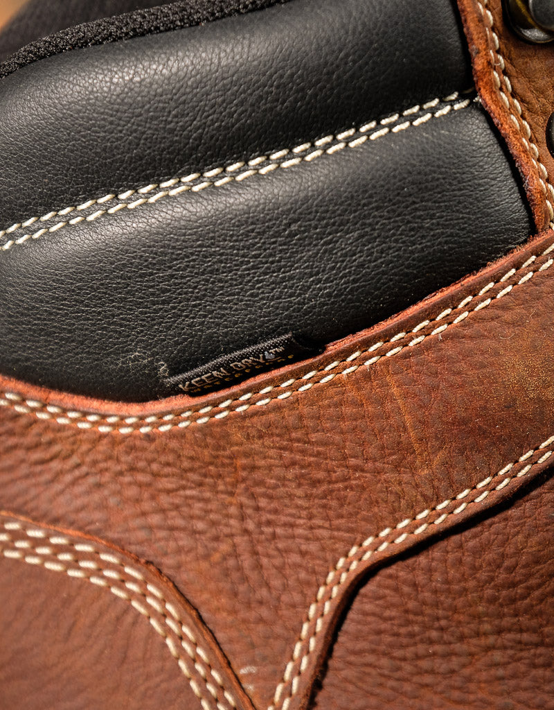 Close-up of brown leather boot with visible stitching and 'Keen Dry' tag