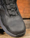 Black boot boot toe on a wooden surface