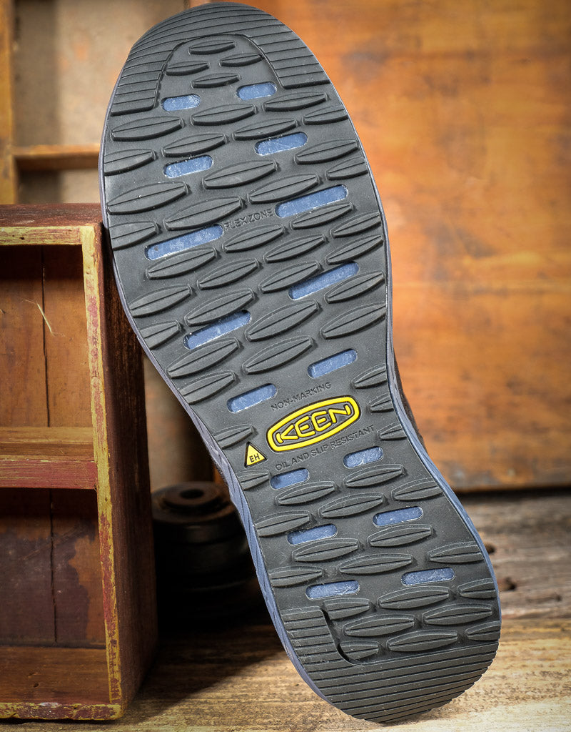 Close-up of a Keen brand shoe sole on a wooden background