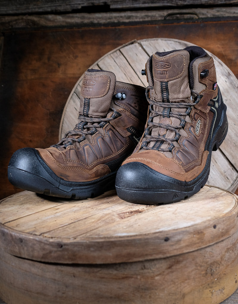 Pair of brown hiking boots on a wooden surface