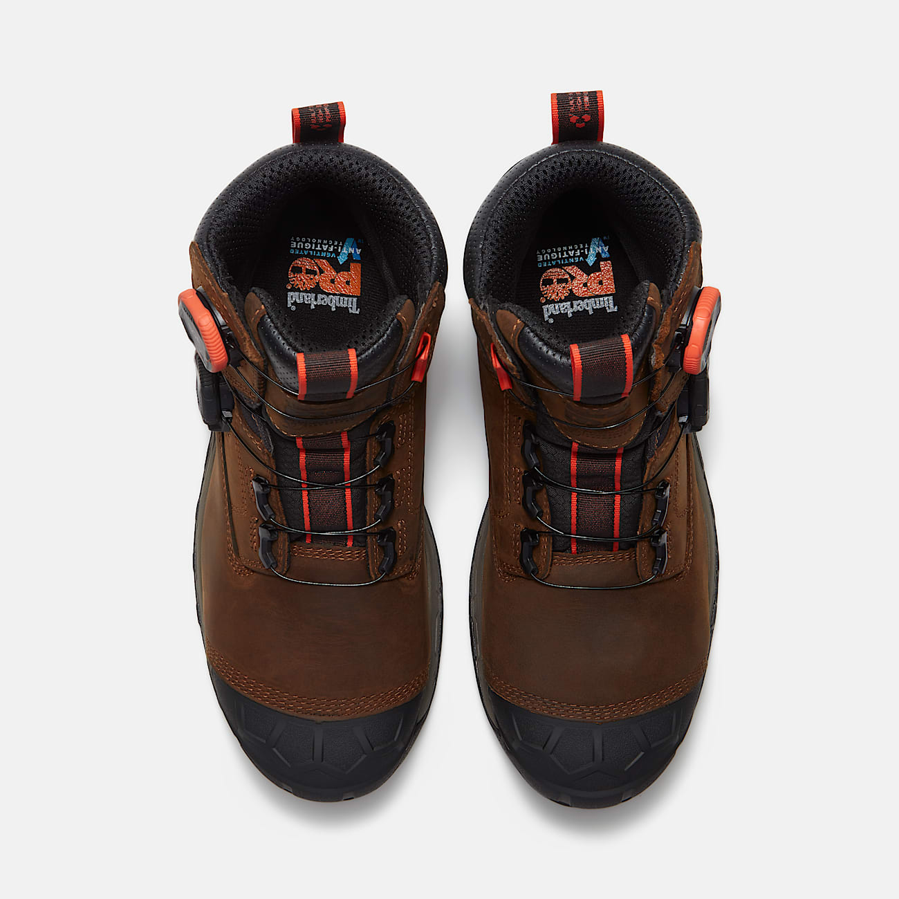 A pair of Timberland Pro hiking boots in brown leather with black and orange accents, shown from a top-down view on a light gray background.