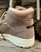 Brown mid top sneaker with pink lining on a wooden surface