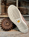 white boot sole with tread pattern on a rustic wooden background