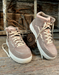 Pair of brown high-top sneakers on a rustic wooden background