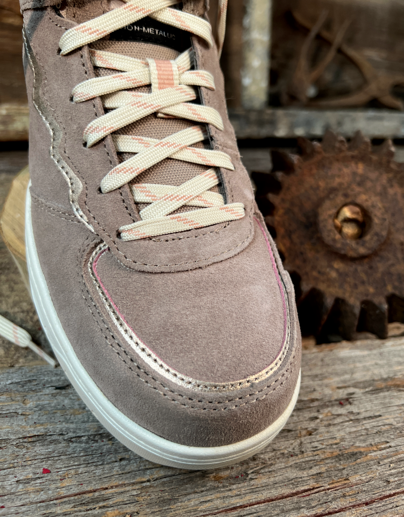 Brown suede sneaker with off-white laces on a rustic wooden surface with gears in the background