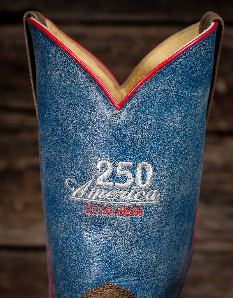 Blue leather boot with '250 America 1776-2024' embroidery on a wooden background