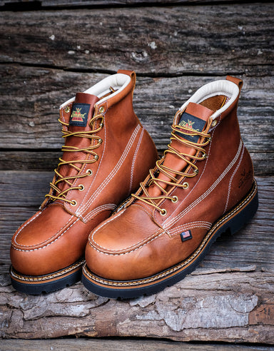 Pair of brown leather boots with laces on a wooden surface