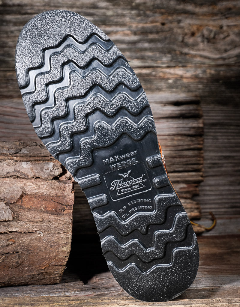 Close-up of a shoe sole with tread pattern on a wooden background