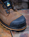 Brown work boot with black toe cap on a textured surface