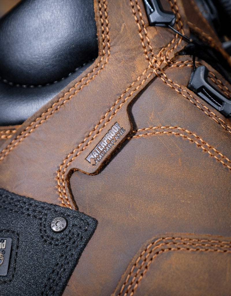 Close-up of a brown leather boot with stitching details and a Waterproof label.