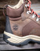Brown hiking boot with visible Timberland logo and waterproof stamp on a wooden surface