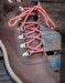 Close-up of a brown boot with red laces on a blurred background