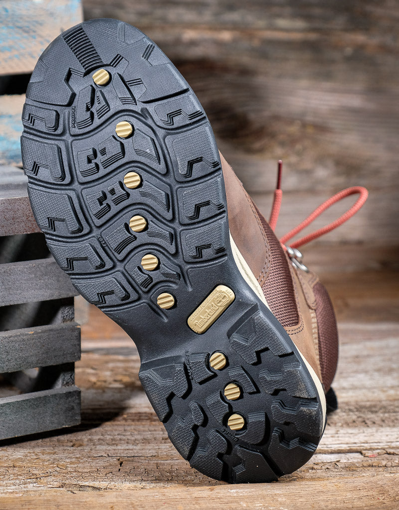 Close-up of a shoe sole with a detailed tread on a wooden surface