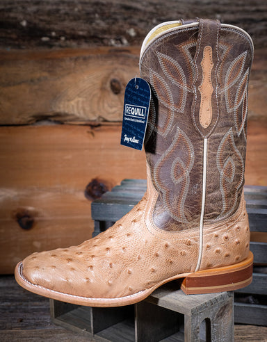 Brown and tan cowboy boot with a Requill tag on a wooden background