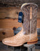 Brown and tan cowboy boot with a Requill tag on a wooden background