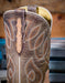 Close-up of a brown leather boot with intricate western stitching and design.
