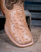 Close-up of a tan ostrich leather boot with detailed stitching on a wooden surface.