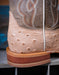 Close-up of a brown leather boot with western stitching on a blurred background