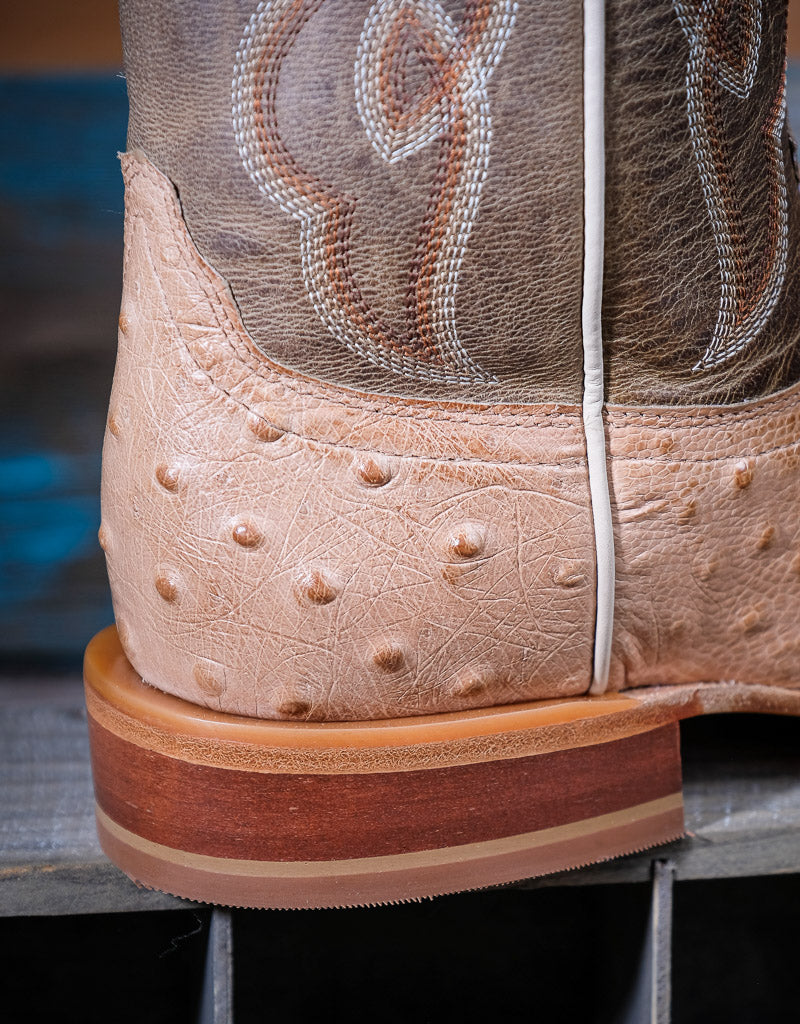 Close-up of a brown leather boot with western stitching on a blurred background