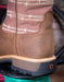 Close-up of a brown boot with barbed wire pattern on a blurred background