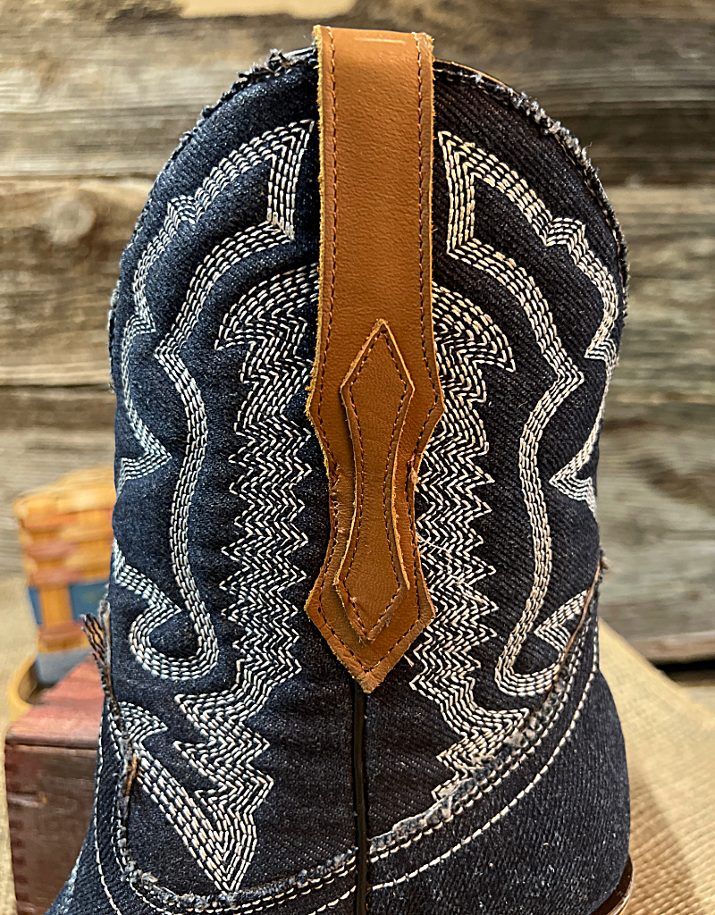 A brown leather boot pull on a denim blue boot