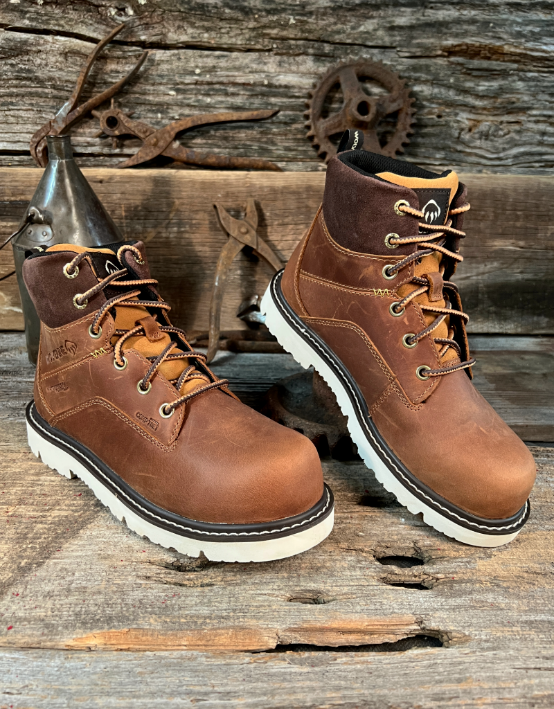 Pair of brown leather boots with white soles on a rustic wooden background.