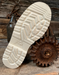 Close-up of a white sole with tread pattern on a rustic wooden background