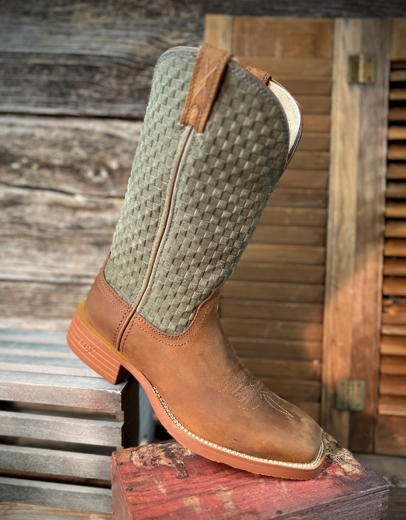 Brown cowboy boot with green patterned shaft on a wooden surface