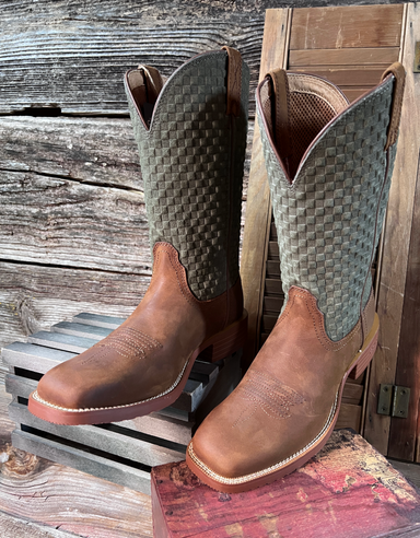 Pair of brown and green cowboy boots on a wooden surface