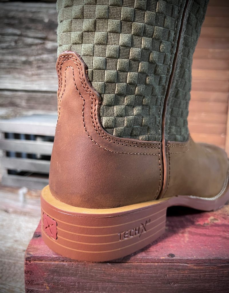 Close-up of a brown boot with a textured green shaft on a wooden surface.