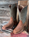 Pair of brown and green cowboy boots on a wooden surface